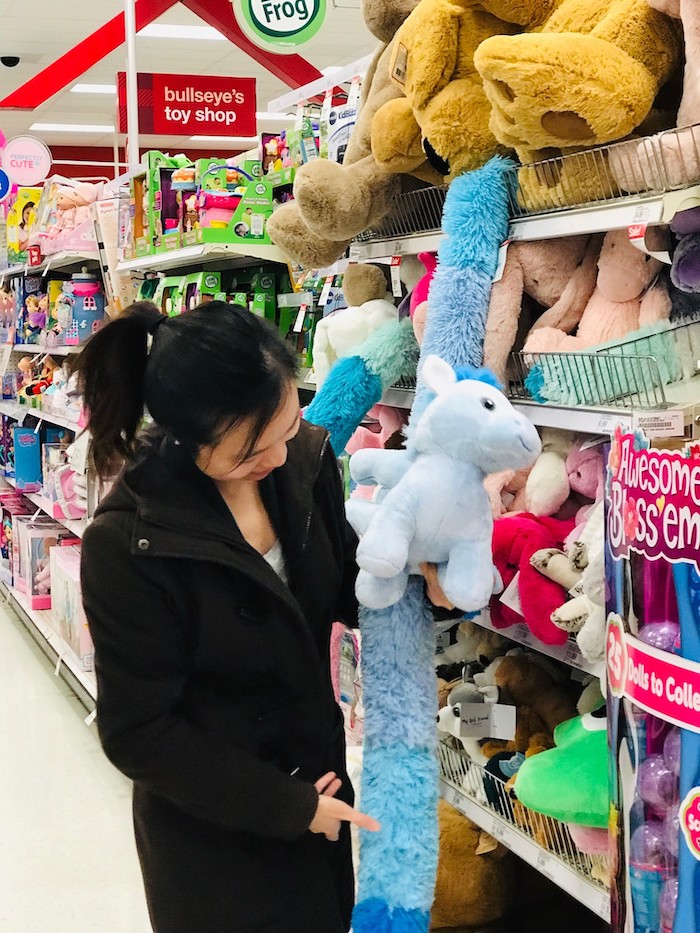 Jolly holds a blue stuffed unicorn toy