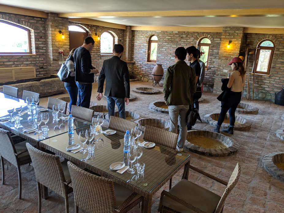 A large group looks at holes in the winery floor