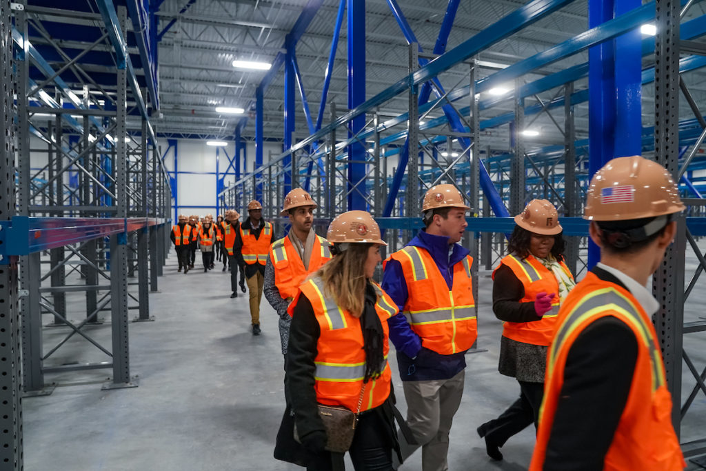 Students tour a building with hard hats