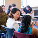 Two women sit in a classroom during a PDP executive education course