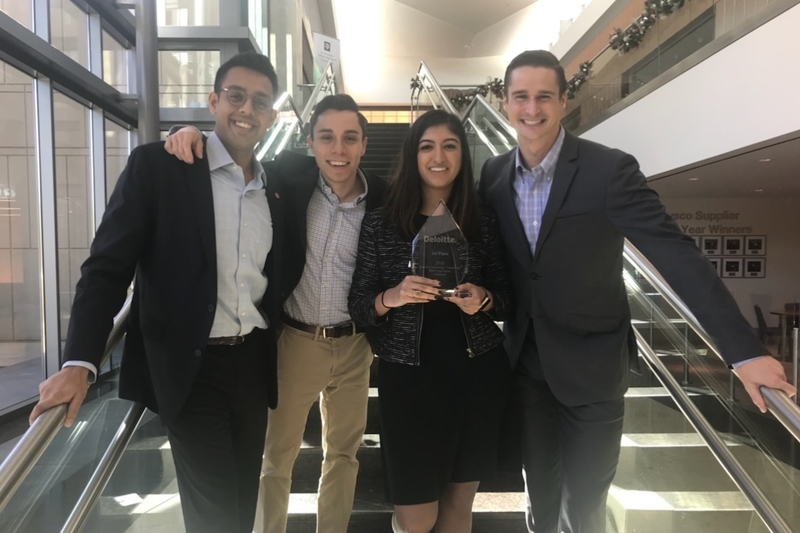 Four happy MBA students display their award.