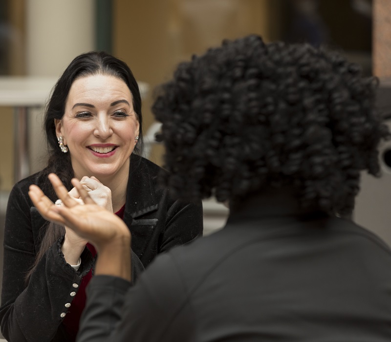 Two students in business attire sit at a table.