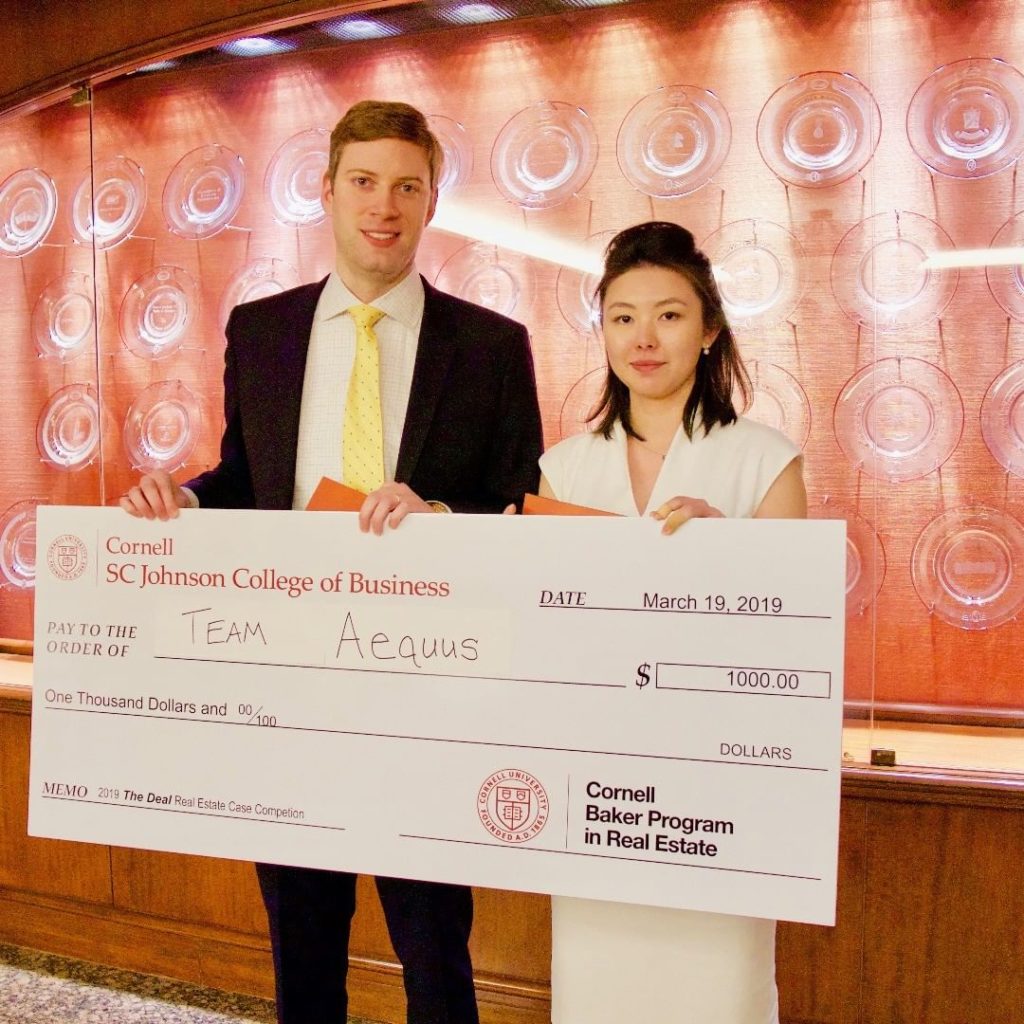 Two students holding an oversized check for $1,000