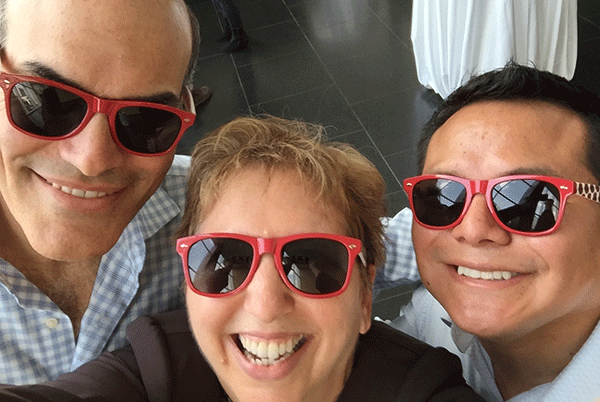 Ann Richards in a selfie with two alumni, all wearing red-framed sunglasses