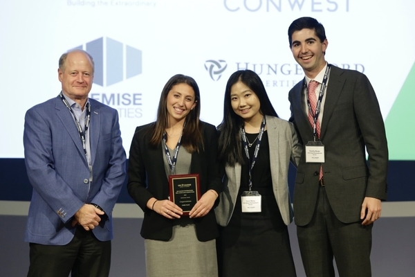 Tori Weissman, Carol Wang, and Tim Bergin stand with judge on stage.