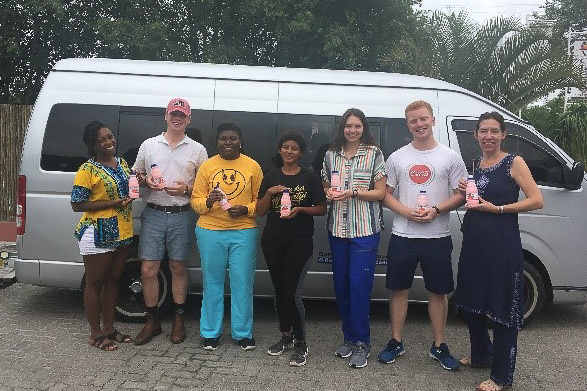 The team standing each holding a drink