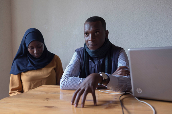 Two people sitting at a desk with a computer