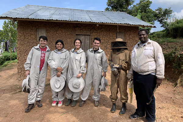 A group standing outside wearing beekeeping gear