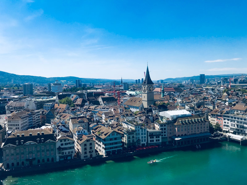 An overhead photo of Geneva with a river, city, and blue sky