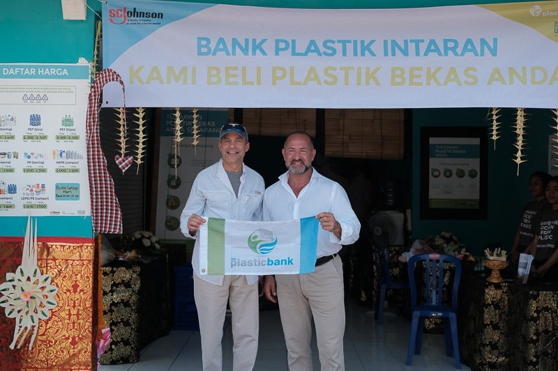 Fish and David hold a banner that says Plasticbank