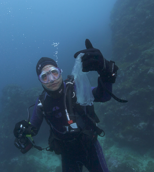 Johnson holds up a piece of plastic in diving gear