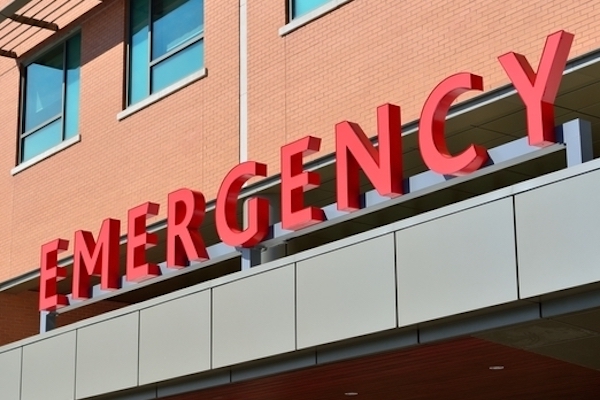 Building with written sign saying emergency in red.
