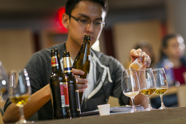 A student pours a sample of beer in class.