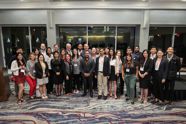 A large group poses for a photo in a reception space