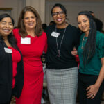 Four women pose for a photo at the 20th anniversary event
