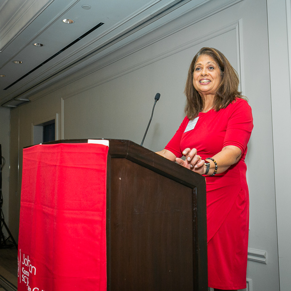 Angela standing at a podium speaking