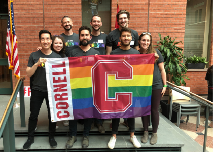 MBAs holding a Cornell rainbow flag