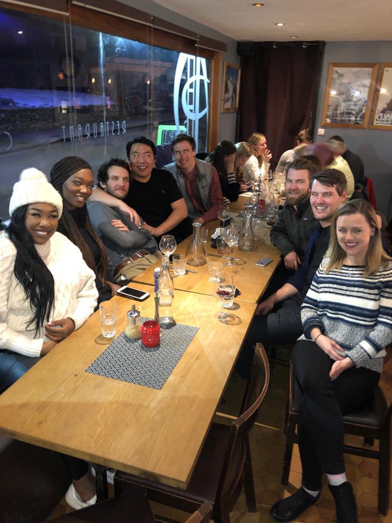  A large group of students pose for a photo over dinner at a restaurant.