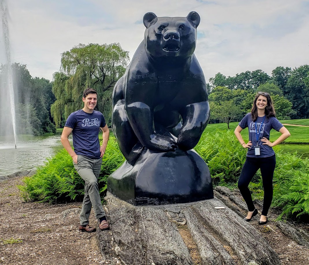 Emily and Taylor standing outside next to a large bear sculpture