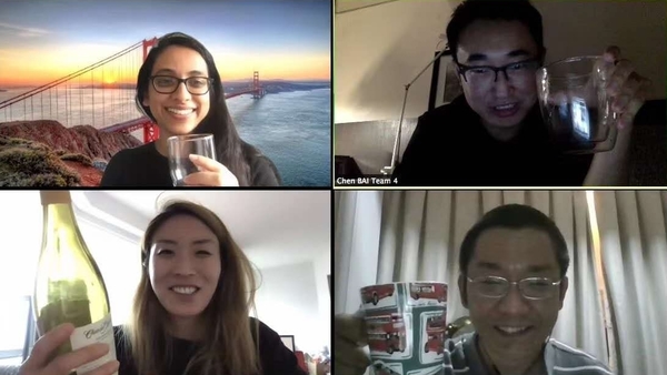 Four students on Zoom raise their glasses in celebration