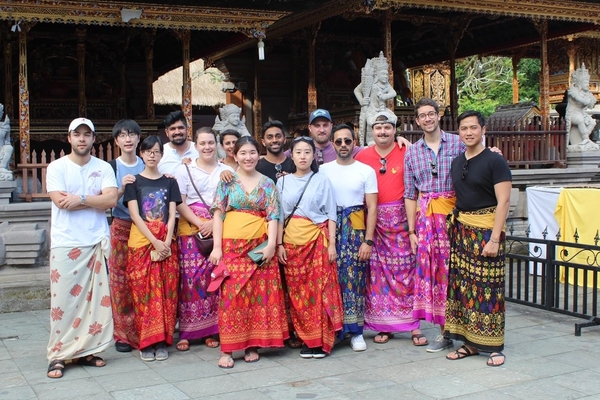 Students pose in bright colored traditional clothing