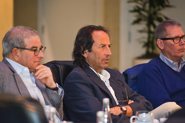 Three men sit next to each other at a table