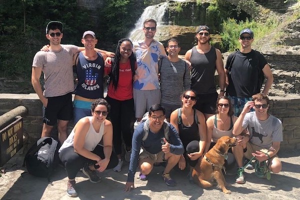 Students stand in front of a waterfall
