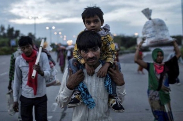 A migrant worker walking with his family as they return to their village.