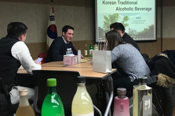 Students sit at a table looking at products