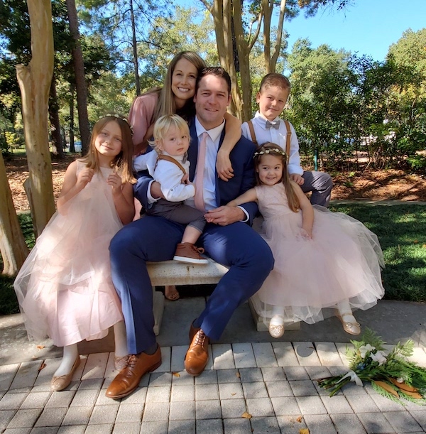 Zach, his wife, and four children pose in formal attire