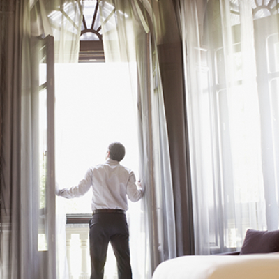 Man looking out hotel room balcony