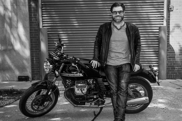 Austin Rothbard leaning against a motorcycle