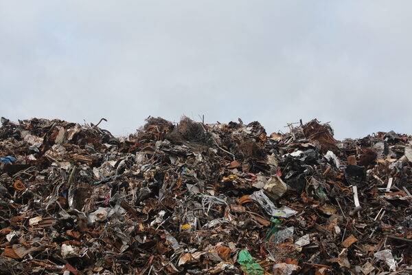 A trash heap is piled high against a clear sky