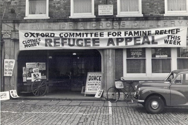 A black and white photo featuring a banner saying, “Oxford Committee for Famine Relief; Refugee Appeal”, Oxfam’s namesake