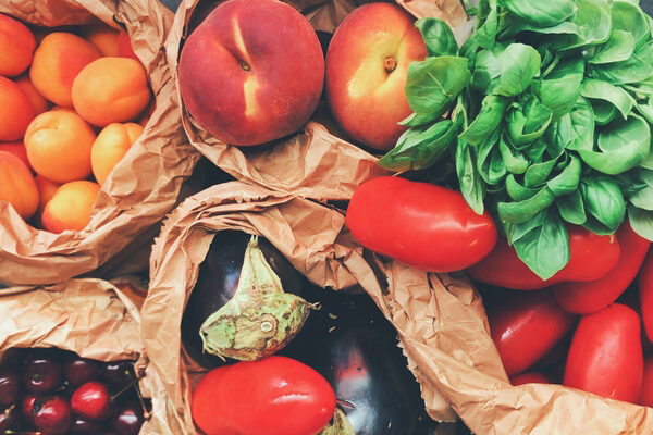 Brown bags filled with fresh fruits and vegetables