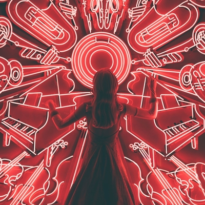 Woman silhouette in front of wall of neon lights