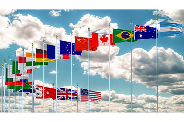 photo of flags of the G20 countries against a blue sky with scattered clouds