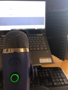 Recording set up for the podcast shows a microphone and computer screen.