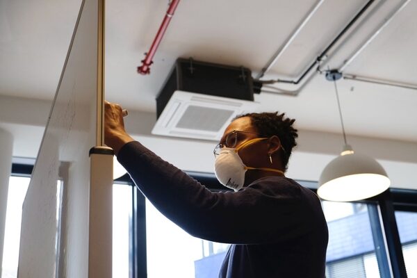 Masked HR person makes a list on a white board