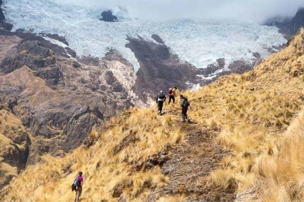 Travelers hiking in a steep, treeless, mountainous landscape