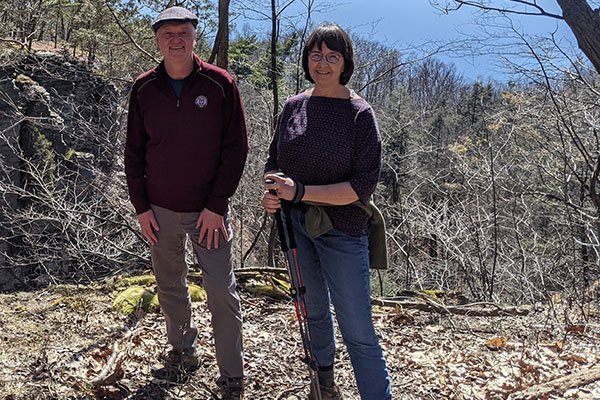 Andrew and Anne Karolyi on a trail in the woods near Ithaca