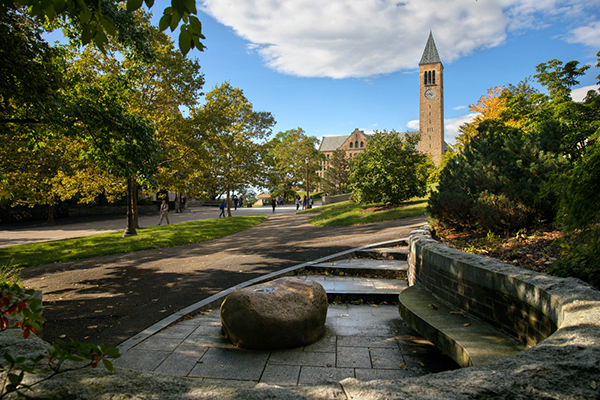 a stone bench in the foreground leading to Hoh Plaza walkway and McGraw Tower in the background