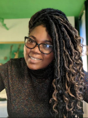 Headshot of Khalilah Olokunola, an African American woman with long hair wearing glasses