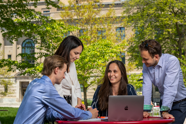 group of students having a discussion over a laptop