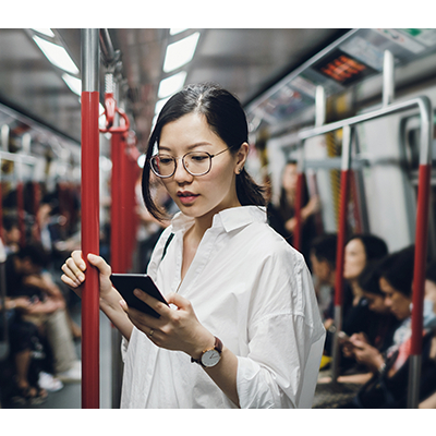 Woman on a train or bus or train looking down at her phone in her hand