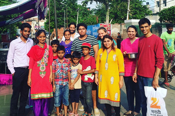 Samay Bansal surrounded by a group of adults and children standing near a kiosk on a city street in Ludhiana, Punjab, India
