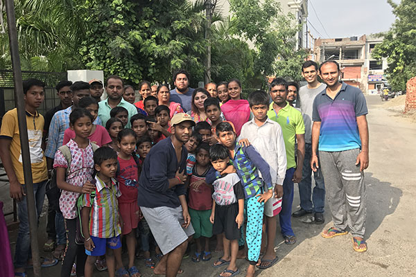 Samay Bansal surrounded by a group of children and adults on a street in Ludhiana, 