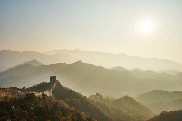 the Great Wall of China surrounded by hills on a foggy morning