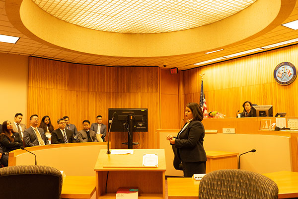 Gage Javier standing and addressing men and women seated in a court room