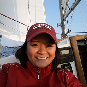 Gage Javier on a sailboat with a sail and mast and blue sky in the bacground